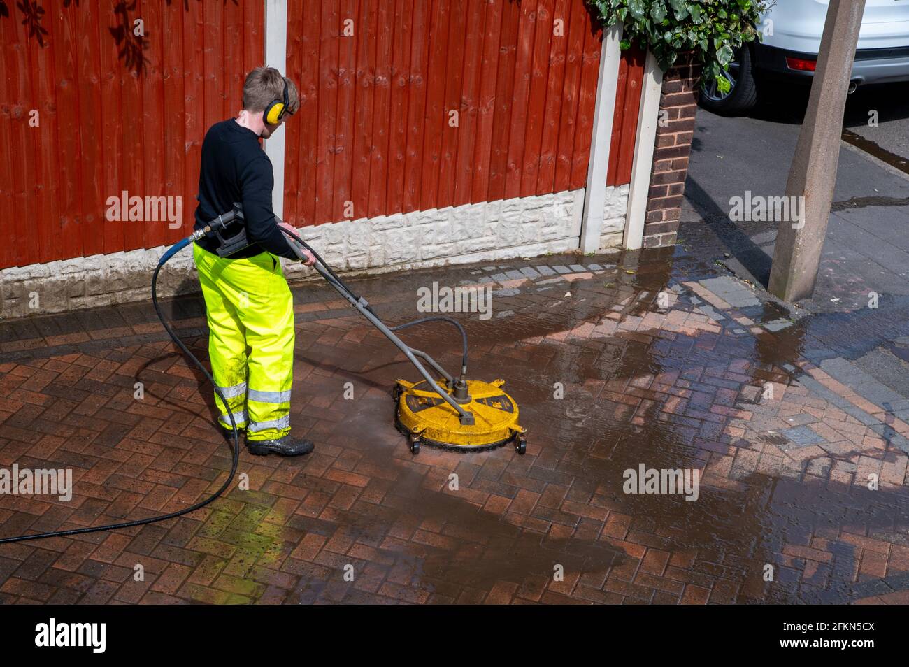 Appaltatori pulizia domestica blocco lastricato vialetto con acqua ad alta pressione Foto Stock