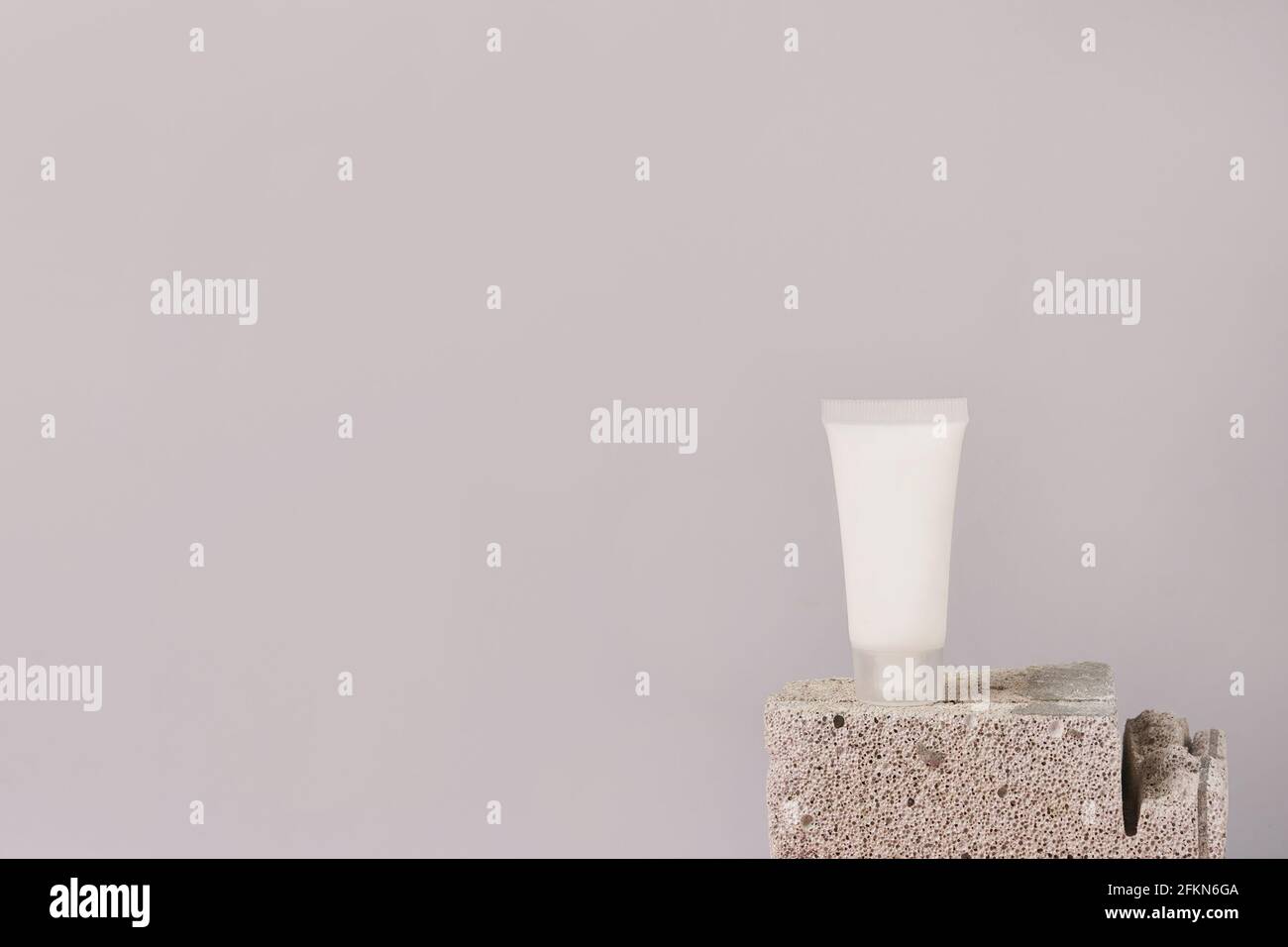 Tubo di crema o gel di plastica bianca sul pietra su sfondo grigio con spazio per la copia Foto Stock