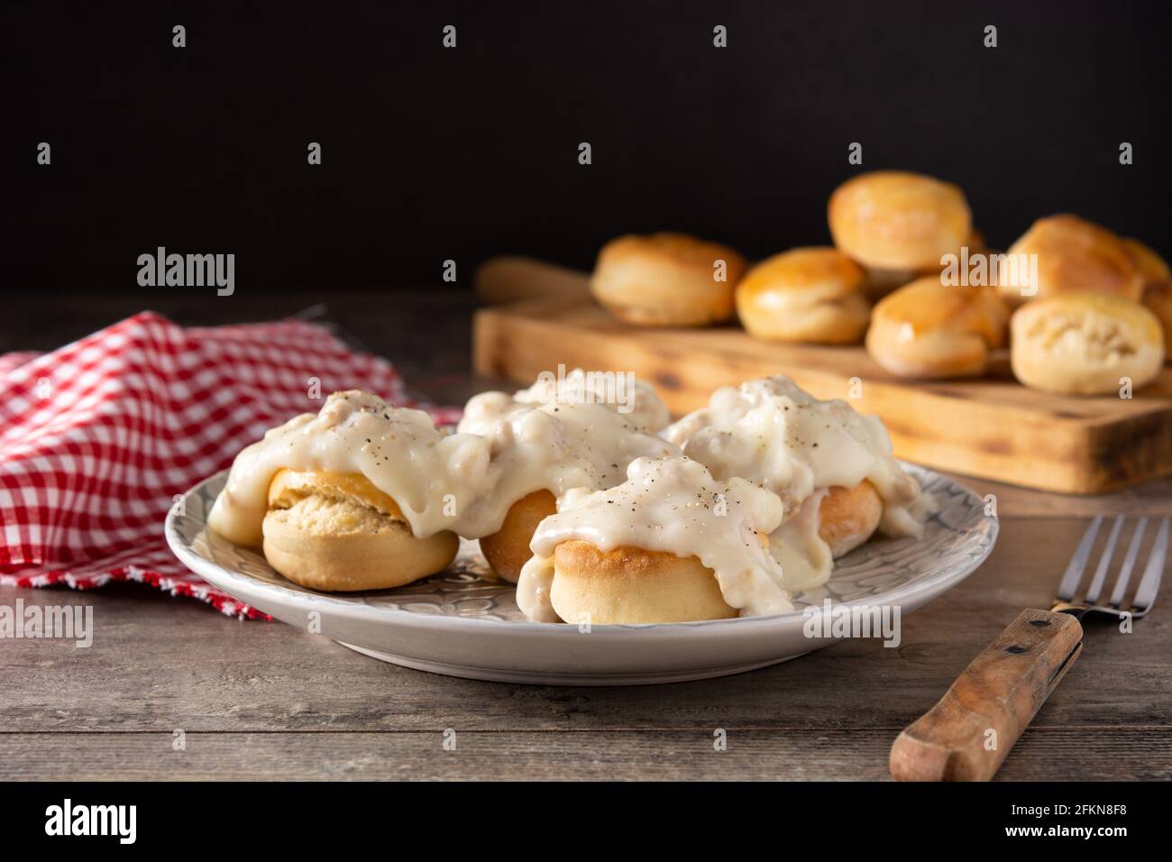 Biscotti americani tradizionali con sugo di carne per colazione su tavolo di legno Foto Stock