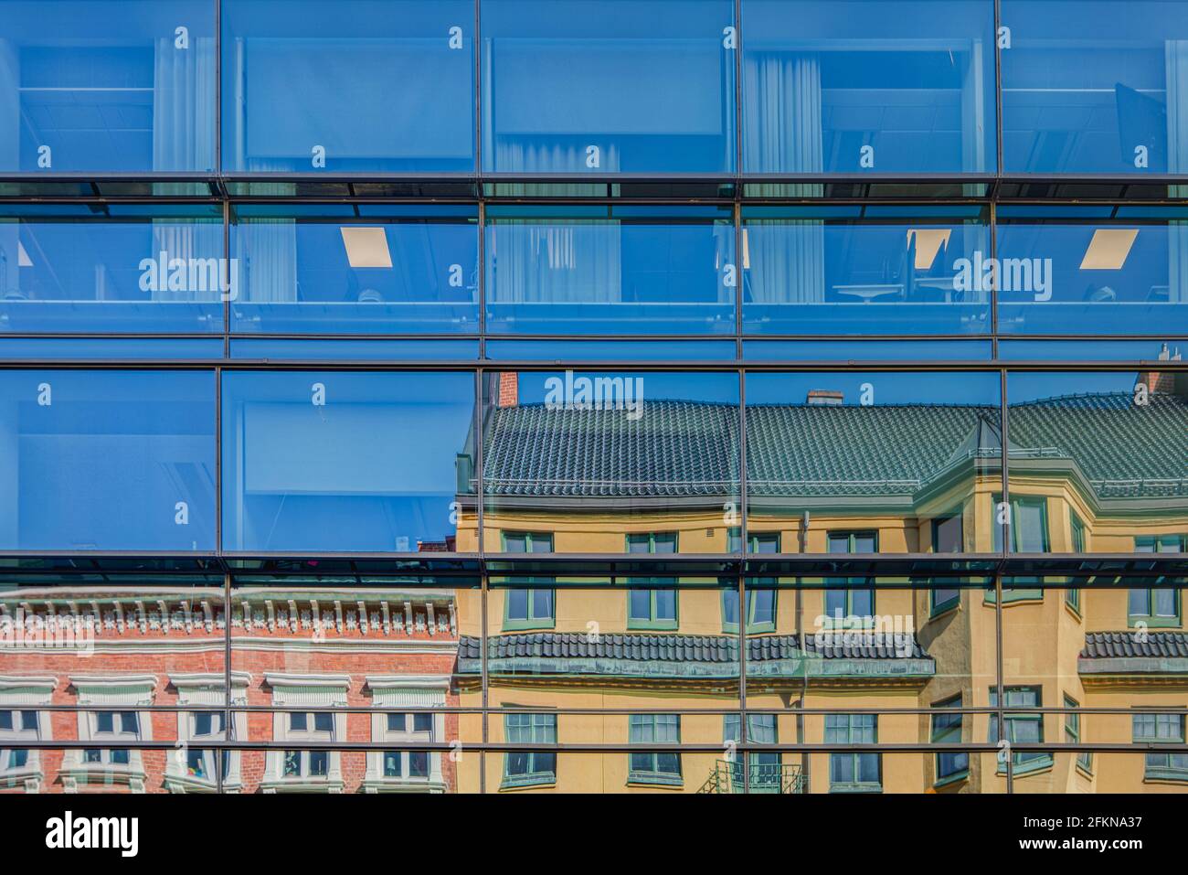 L'architettura moderna incontra un vecchio edificio storico dove il vecchio classico gli edifici si riflettono in una facciata di uffici smaltata in citta' il quartiere del centro Foto Stock
