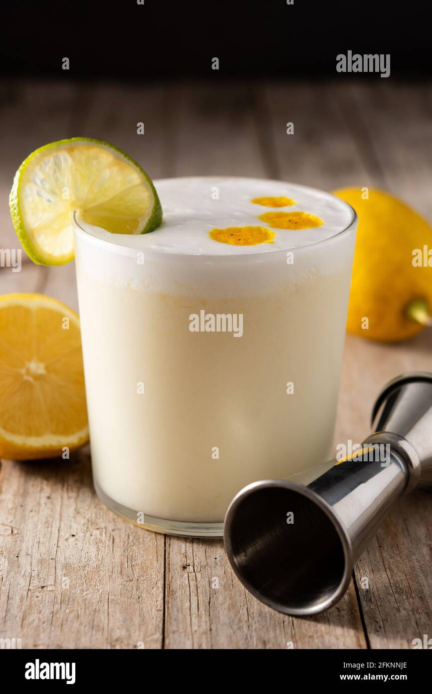 Cocktail Pisco sour su tavolo di legno. Cocktail peruviano tradizionale Foto Stock