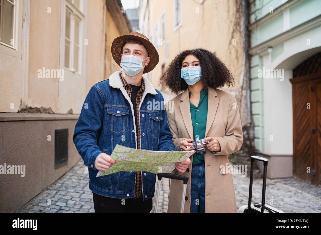 Giovani coppie di turisti con mappa sulla vacanza nel centro storico, concetto di coronavirus. Foto Stock