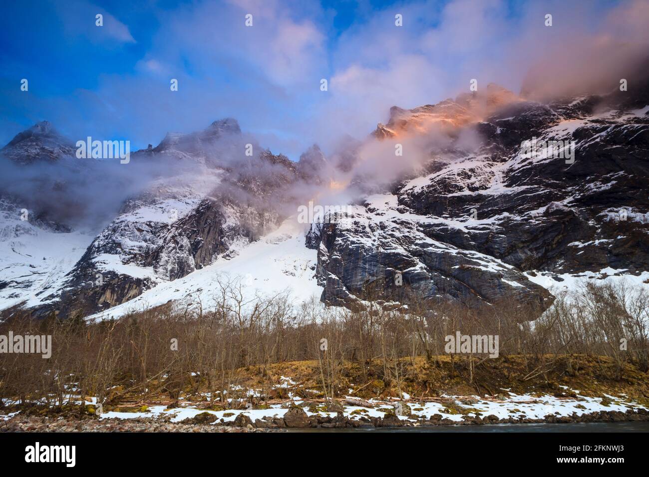 Sole di mattina presto sulle montagne nebbie nella valle di Romsdalen, Rauma kommune, Møre og Romsdal, Norvegia, Scandinavia. Foto Stock
