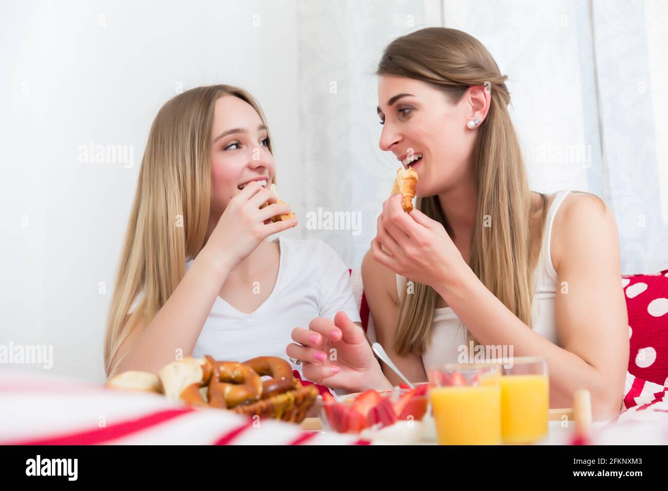 Madre e figlia che hanno la prima colazione a letto Foto Stock