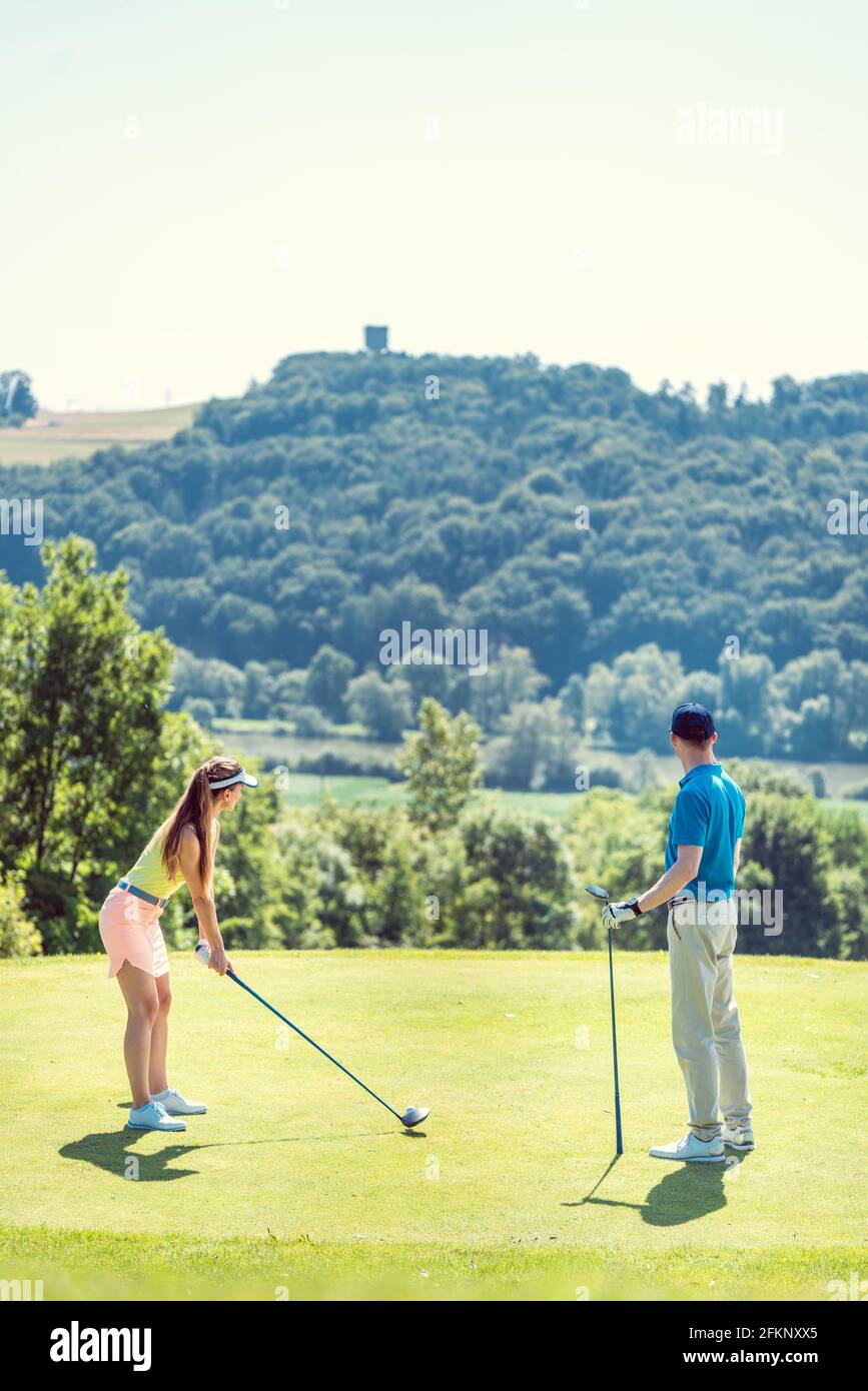 Coppia giocando a golf in una giornata estiva Foto Stock