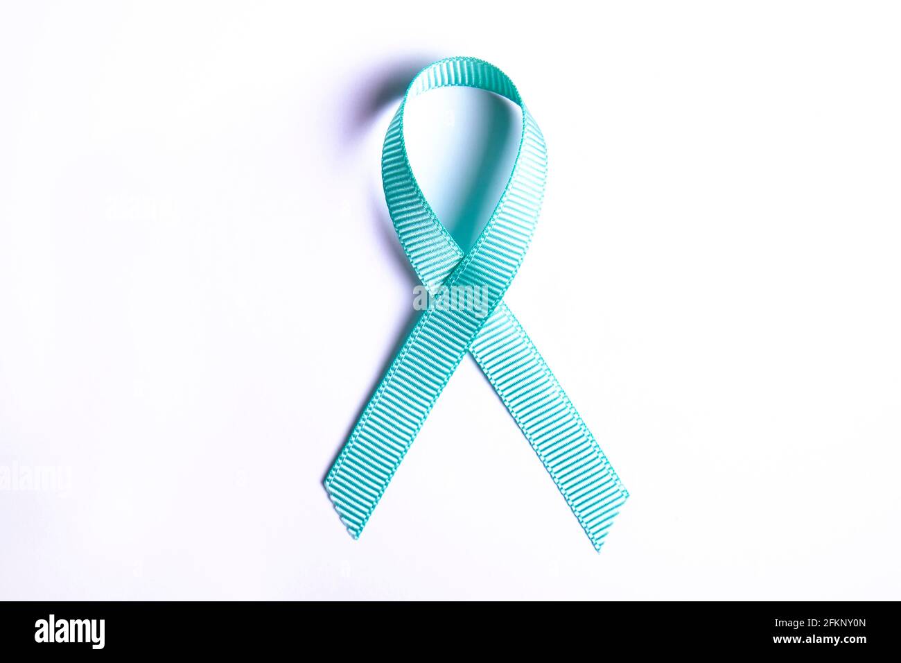 Nastro di consapevolezza blu - simbolo per combattere il cancro della prostata, sostenere i sopravvissuti e la consapevolezza dell'abuso di bambini. Isolato su sfondo bianco, spazio di copia Foto Stock
