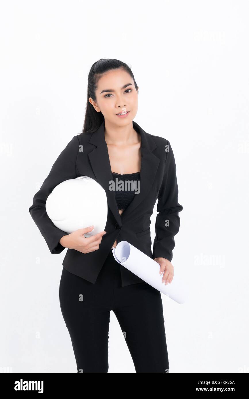 Ritratto giovane ingegnere donna che indossa tuta nera che regge blueprint e caschetto di sicurezza bianco in studio di tiro isolato su sfondo bianco. Foto Stock