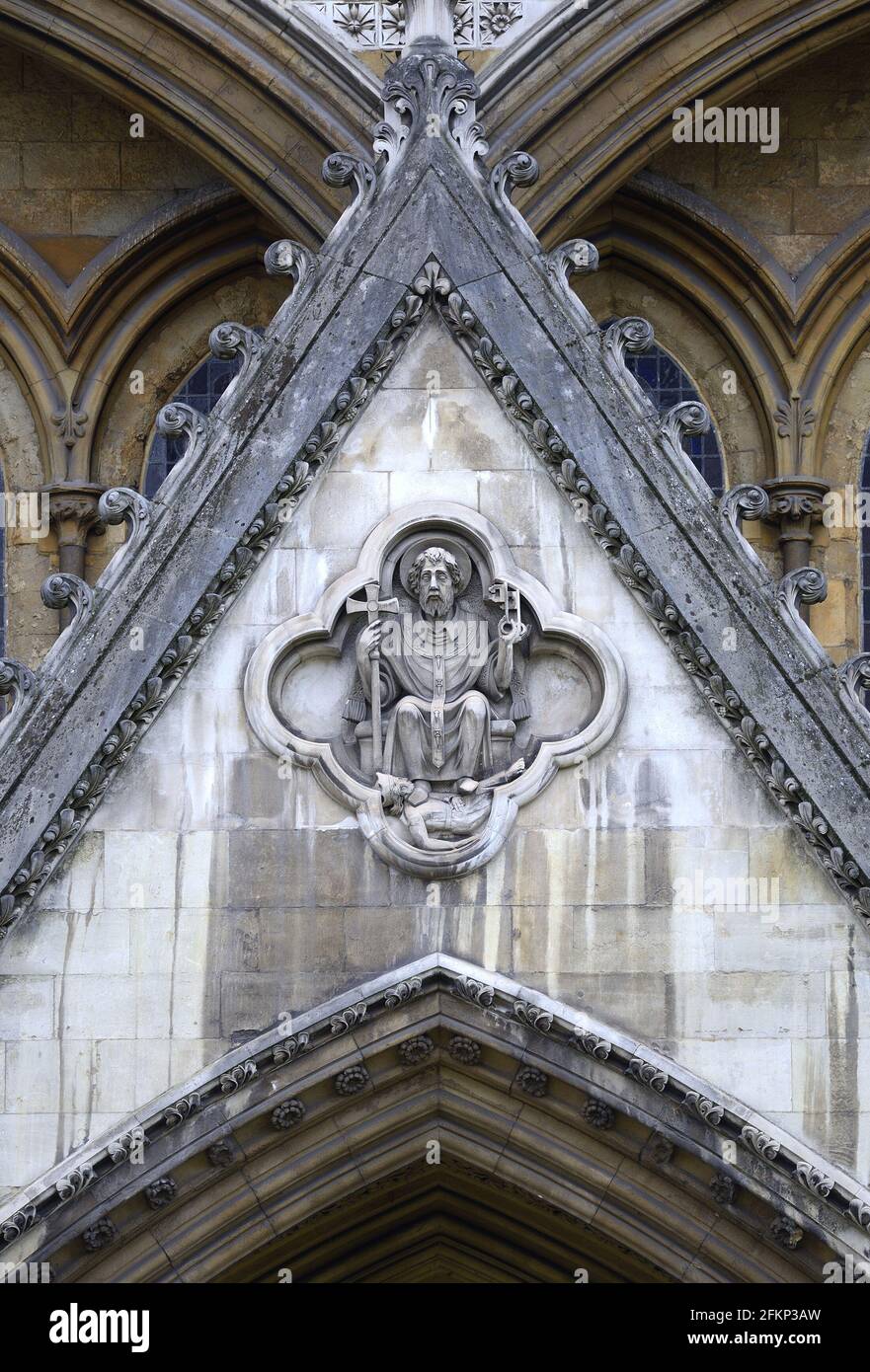 Londra, Inghilterra, Regno Unito. Scultura in pietra di San Pietro calpestata sul Diavolo, sopra la porta nord Foto Stock