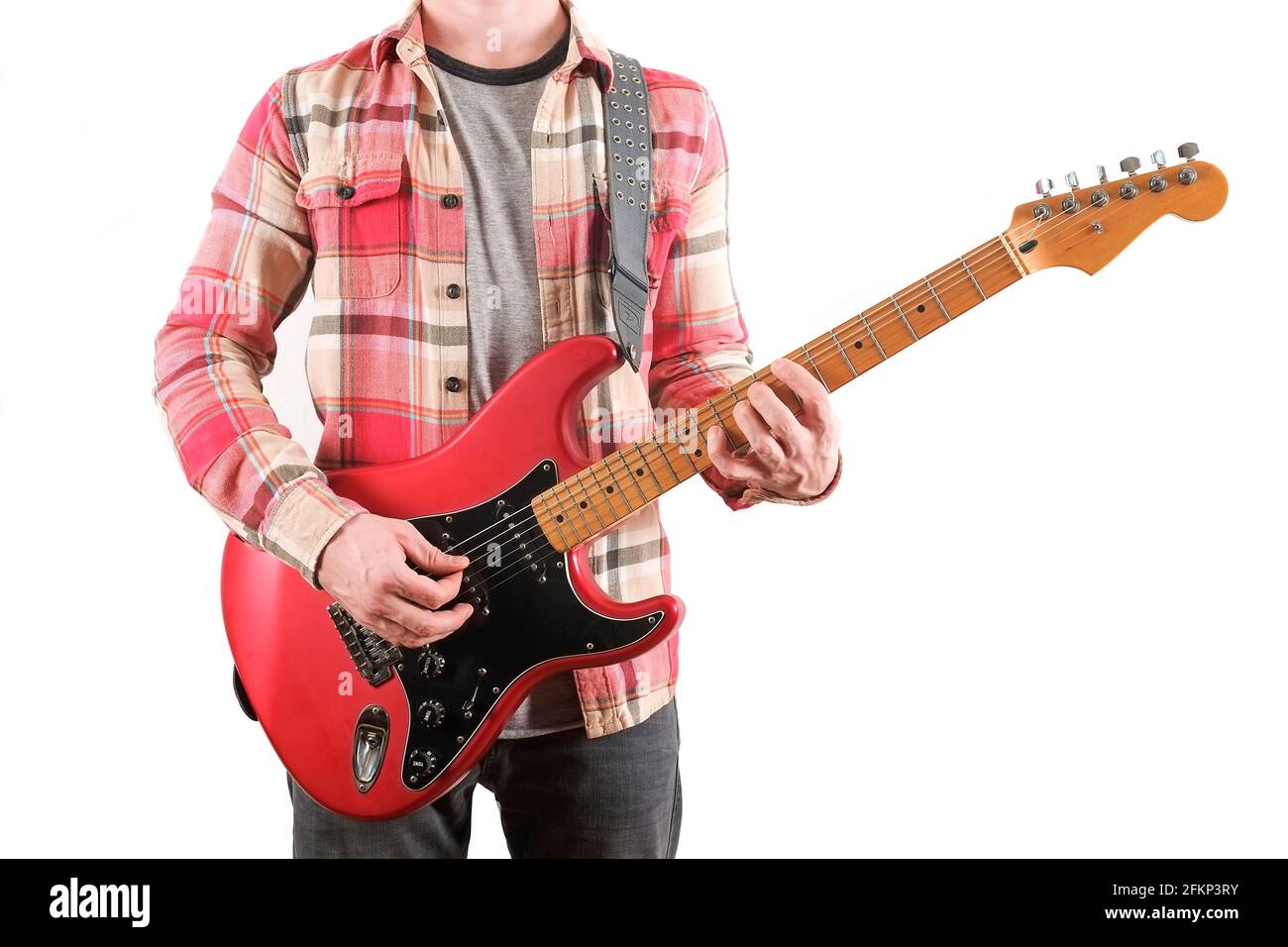 Chitarrista rock in camicia a quadri a scacchi che suona una chitarra elettrica candy mela rossa con bobina singola, collo d'acero e pickguard nero. Uomo che tiene musica inst Foto Stock