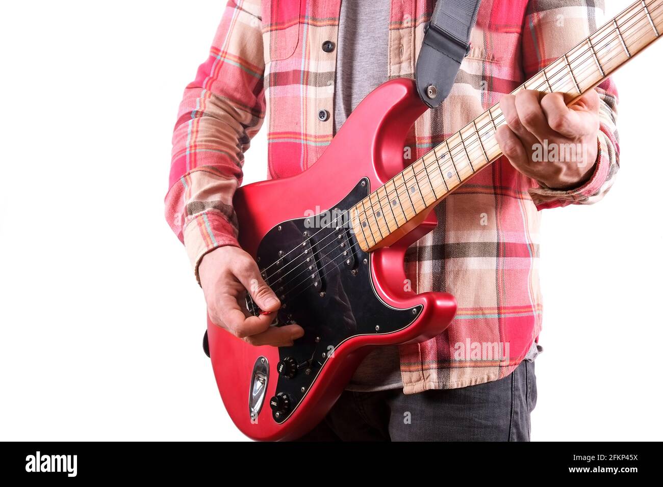 Chitarrista rock in camicia a quadri a scacchi che suona una chitarra elettrica candy mela rossa con bobina singola, collo d'acero e pickguard nero. Uomo che tiene musica inst Foto Stock