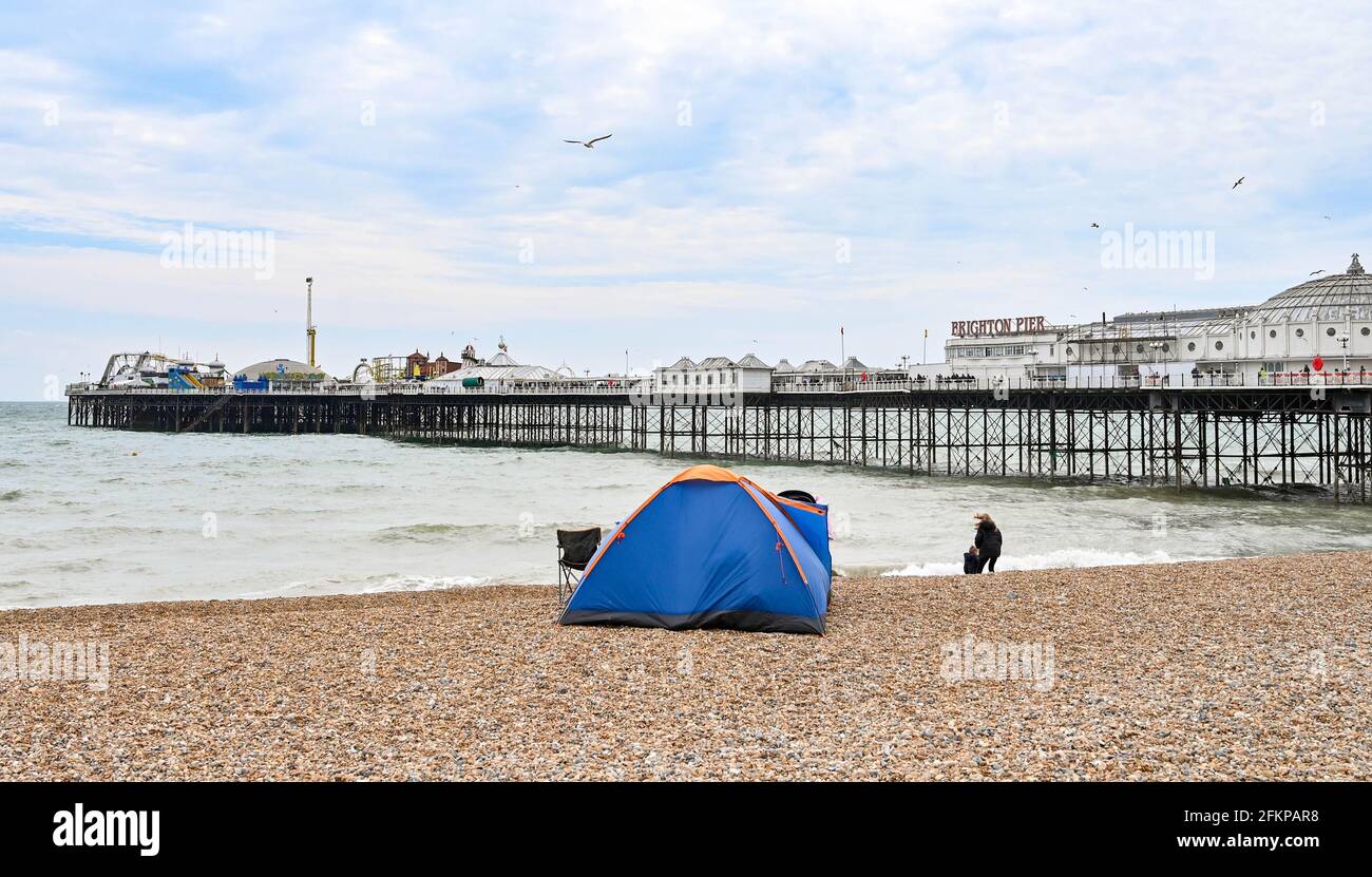 Brighton Regno Unito 3 maggio 2021 - una tenda di famiglia ambrata sulla spiaggia di Brighton come i visitatori godono la festa della Banca di maggio nonostante il tempo ventoso: Credit Simon Dack / Alamy Live News Foto Stock