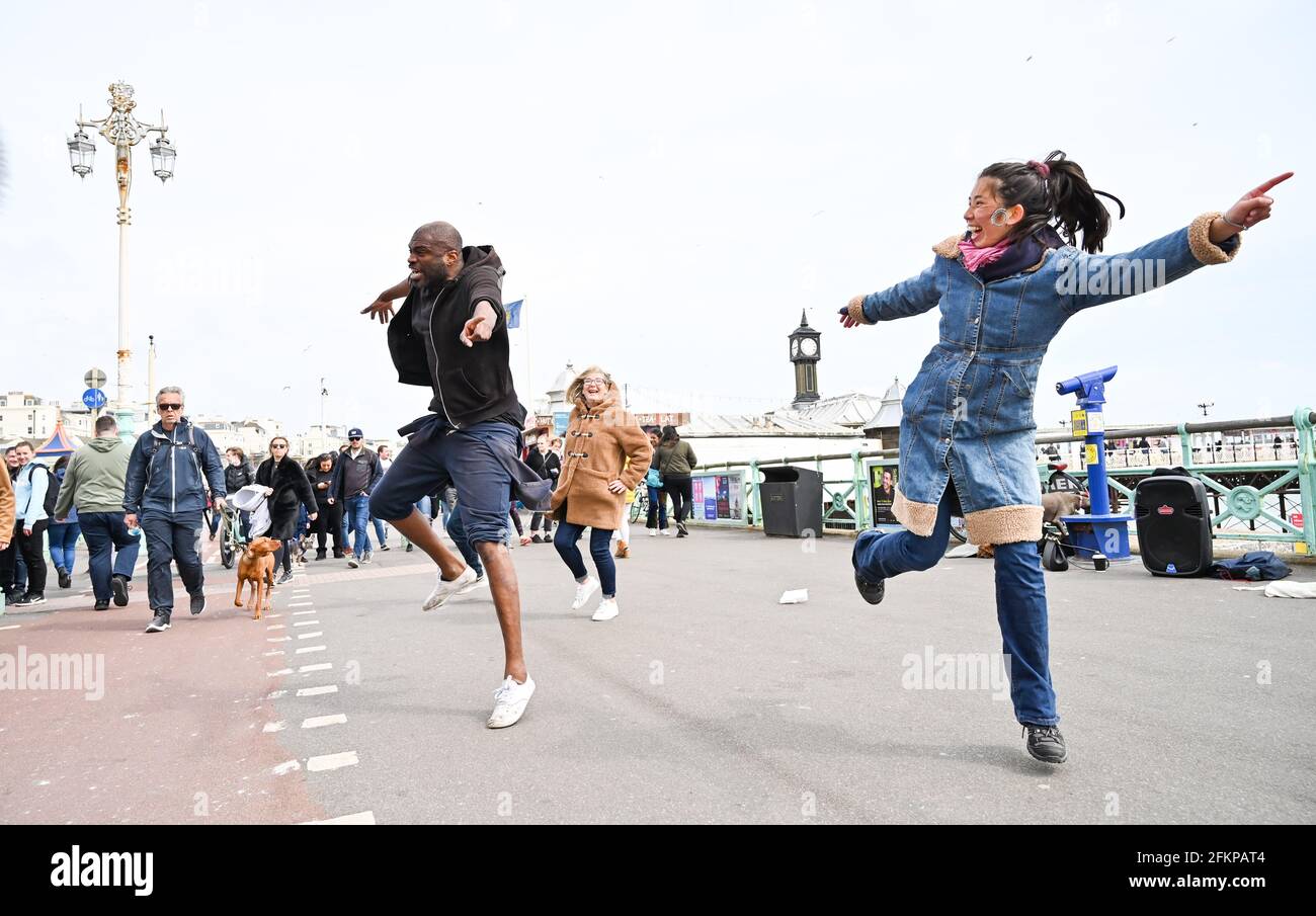 Brighton UK 3 maggio 2021 - Danza in strada sul lungomare di Brighton come i visitatori godono la May Bank Holiday nonostante il tempo ventoso: Credit Simon Dack / Alamy Live News Foto Stock