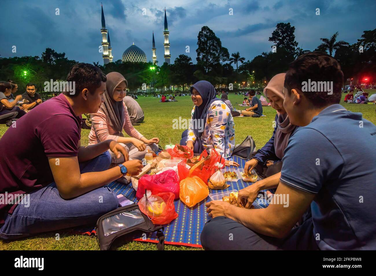 Kuala Lumpur, Malesia. 27 Apr 2021. I musulmani malesi si rompono velocemente mentre praticano l'allontanamento sociale durante il Ramadan in un campo di fronte alla moschea di Shah Alam. Il pubblico è stato invitato a continuare ad aderire alle procedure operative standard (SOP) durante la rottura di eventi veloci per frenare la diffusione del coronavirus. Credit: SOPA Images Limited/Alamy Live News Foto Stock