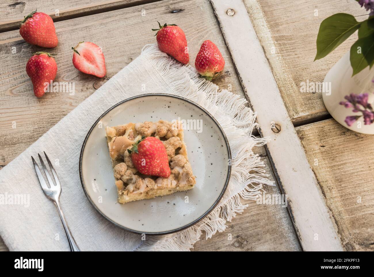 Pezzo di torta di rabarbaro e fragole su un piatto su un vecchio tavolo di legno Foto Stock