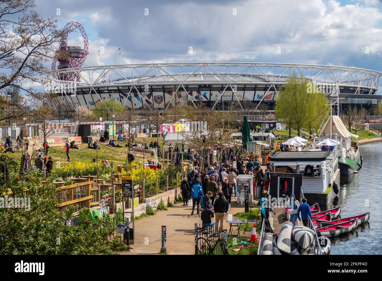 LONDRA, Regno Unito - 11 APRILE 2021: La gente fuori dai canali bar a Hackney Wick a Londra in una giornata di sole. Sullo sfondo è possibile vedere il West Ham Stadium. Foto Stock