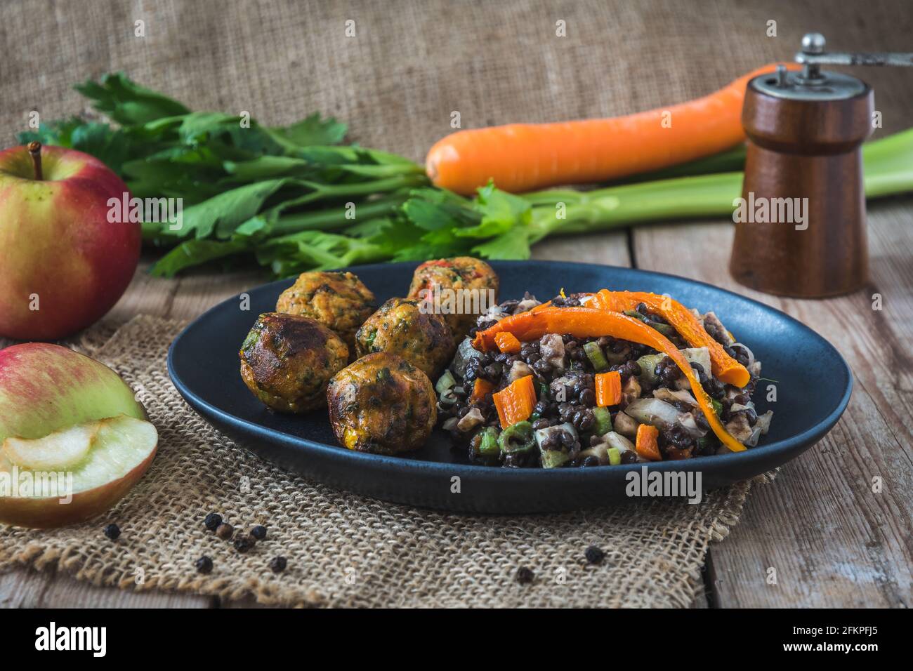 Palle di verdure grigliate con insalata di lenticchie, sedano, carote e mela su un tavolo di legno, concetto di cibo vegano Foto Stock