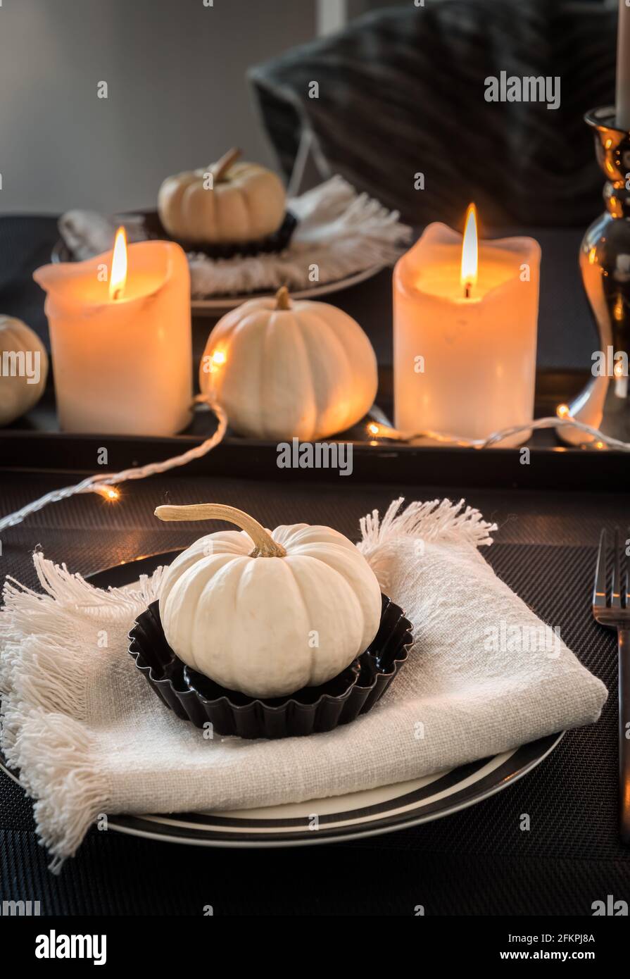 Posizionare le impostazioni in bianco e nero decorate con zucche bianche e candele bianche, foto verticale Foto Stock