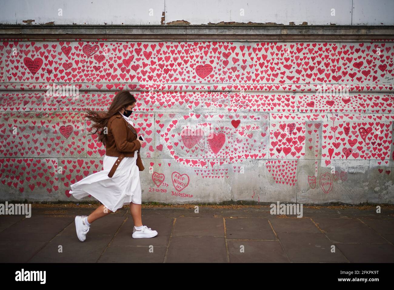 Una donna passa davanti al National Covid Memorial Wall sull'argine di Londra, dopo l'ulteriore allentamento delle restrizioni di blocco in Inghilterra. Data immagine: Lunedì 3 maggio 2021. Foto Stock