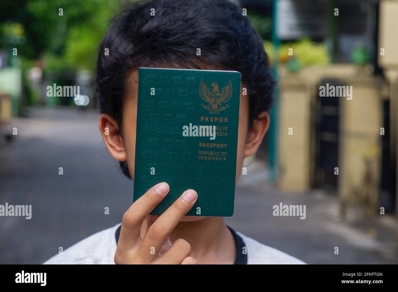 Indonesiano bambino con passaporto Repubblica di Indonesia di fronte al suo volto, selezionato fuoco. Foto Stock