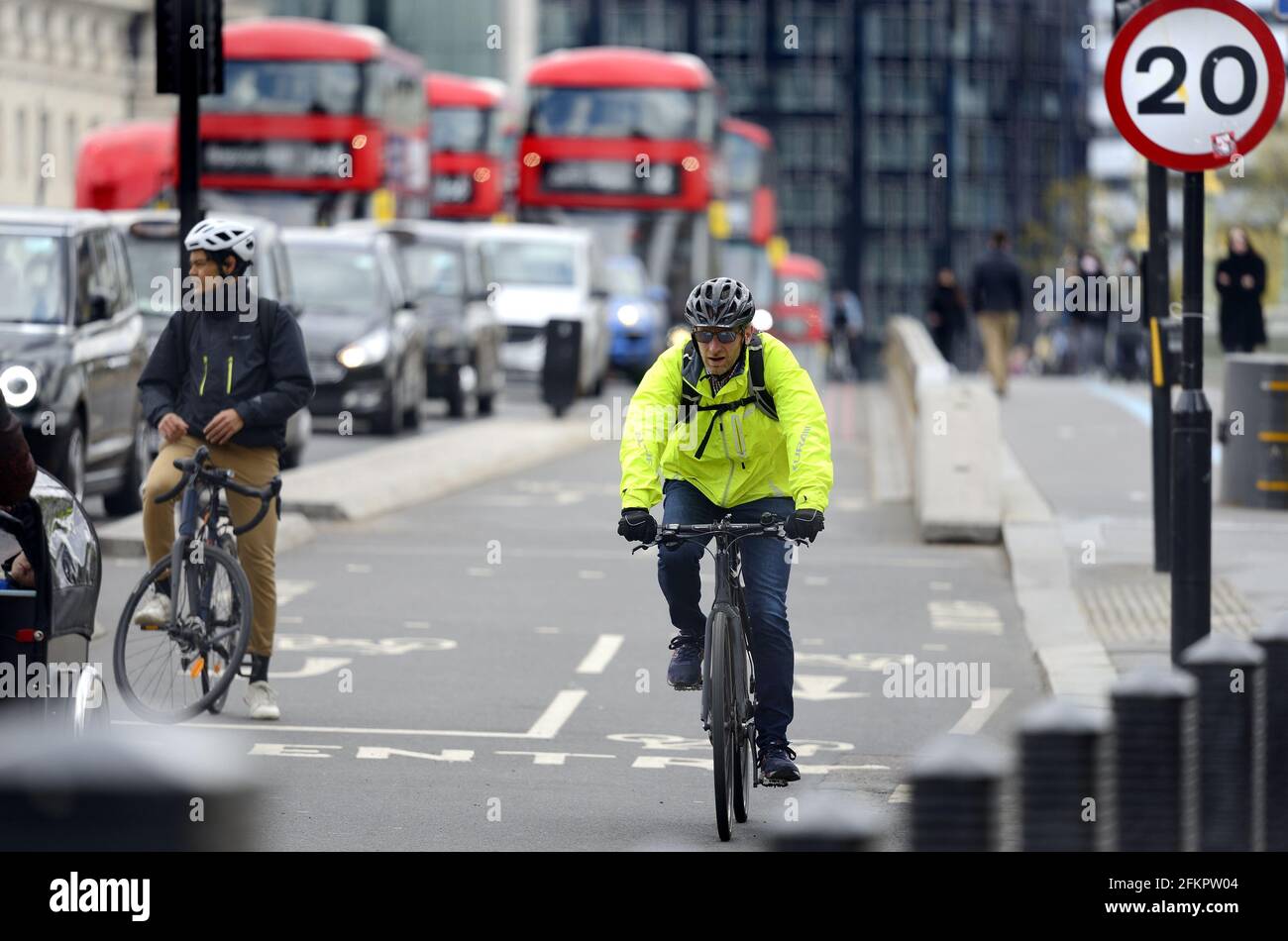 Londra, Inghilterra, Regno Unito. Ciclista su Westminster Bridge, nella pista ciclabile Foto Stock
