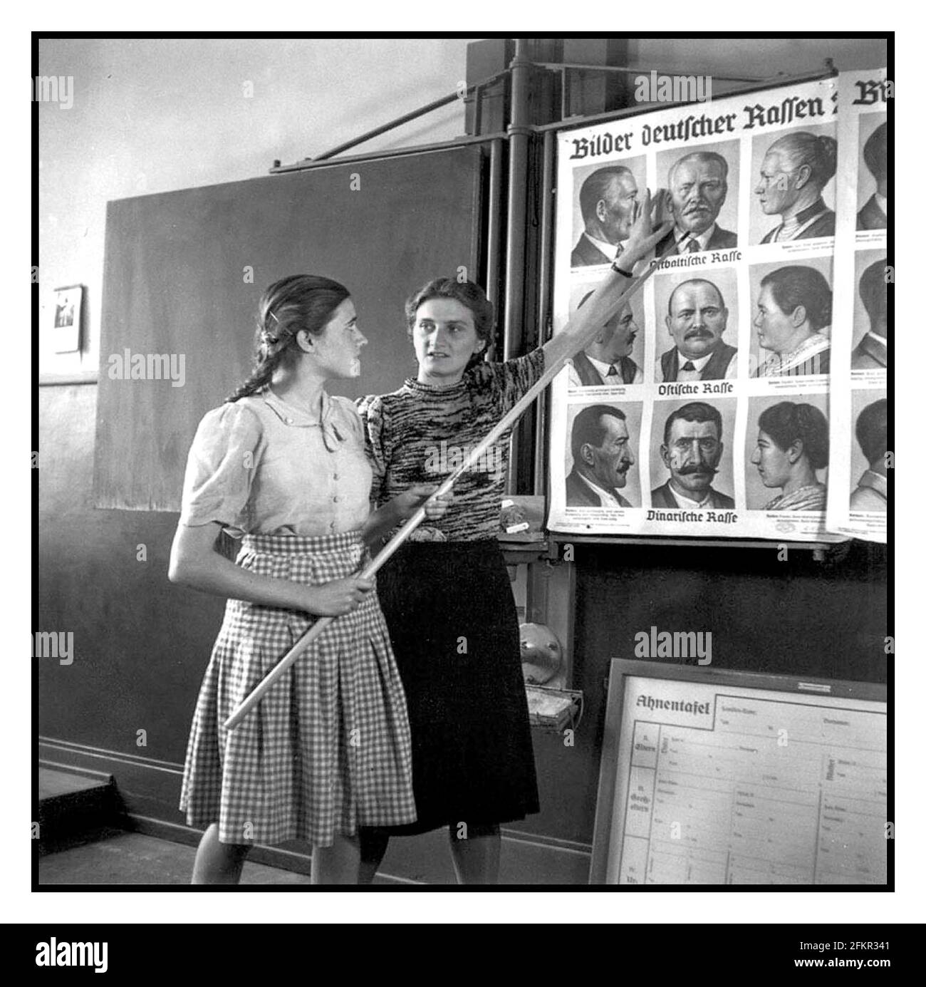 Germania nazista educazione scolastica indottrinamento radicalizzazione immagine degli anni '1940 di una classe di educazione razziale in una scuola per ragazze tedesche, 1943 mostrando poster con varie caratteristiche facciali tedesche che sarebbero accettabili per l'ideale nazista. - L'indottrinamento nazista ha permeato tutta la vita familiare tedesca. L'educazione nel terzo Reich servì ad indottrinare gli studenti con la visione del mondo nazionalsocialista. Gli studiosi e gli educatori nazisti hanno glorificato le razze nordiche e le altre razze "ariane", etichettando gli ebrei e altri popoli cosiddetti inferiori come "razze parassitarie incapaci di creare cultura o civiltà". Germania nazista 2T6XHP Foto Stock
