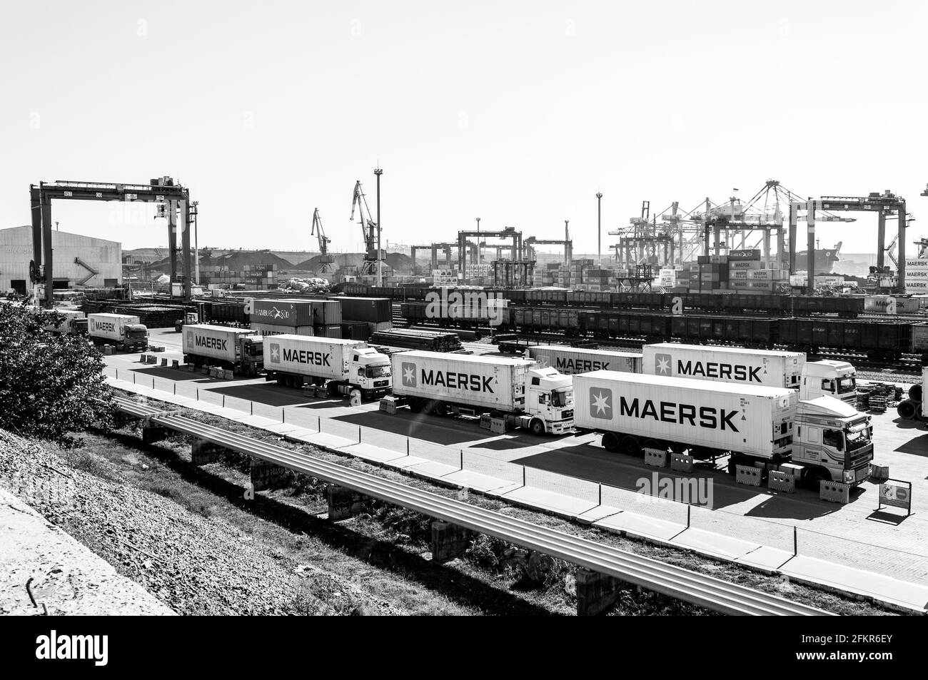 Vista panoramica del terminal dei container TIS nel più grande porto di carico secco dell'Ucraina. Paesaggio industriale bianco e nero di porto ormeggio con containe Maersk Foto Stock