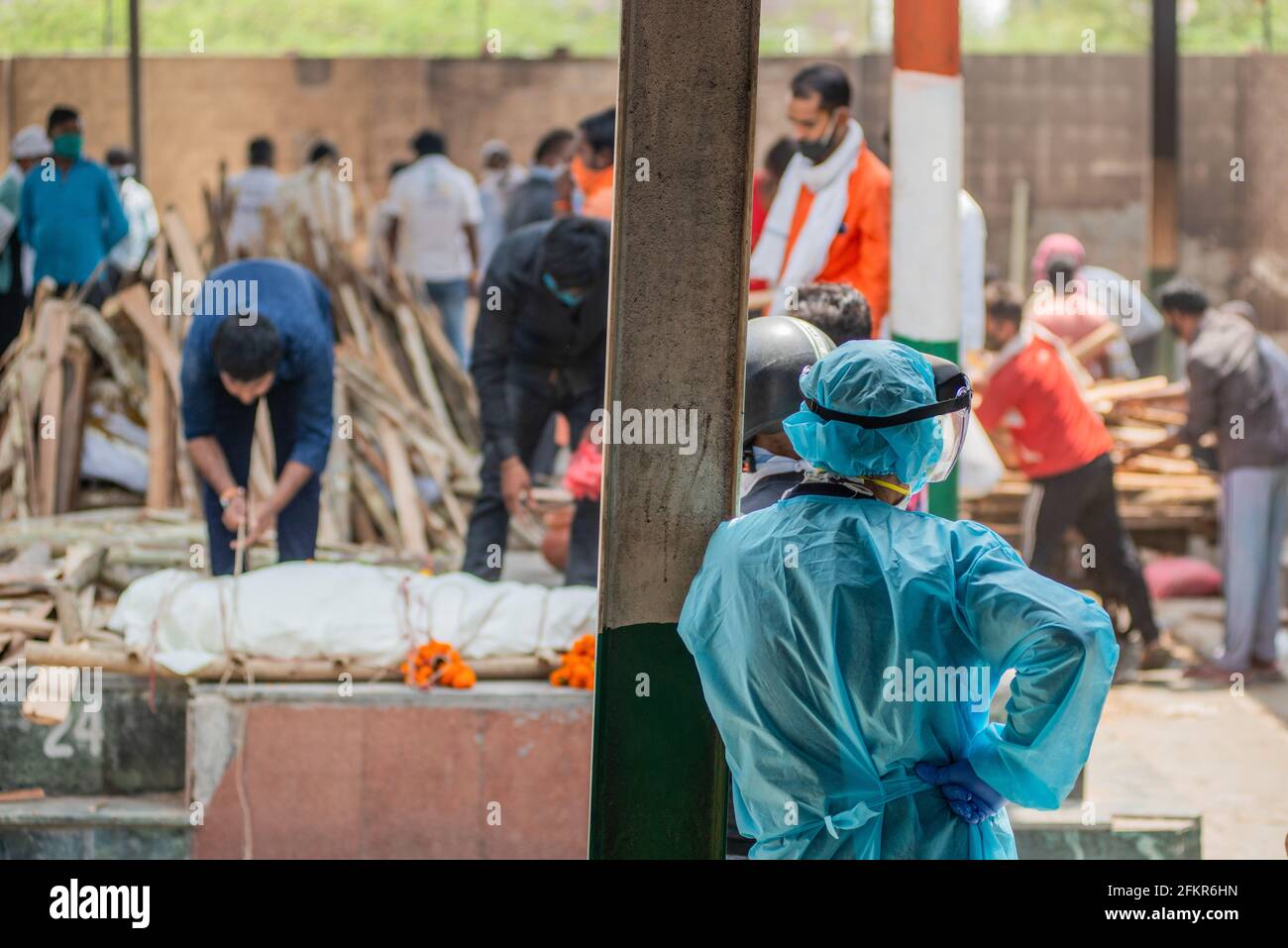 Nuova Delhi, India. 03 maggio 2021. NOTA DELLA REDAZIONE (immagine della morte) UN pianificatore che indossa un kit di dispositivi di protezione personale (PPE) guarda alle pire funerarie di persone che sono morte di Covid-19, durante una cremazione di massa al crematorio municipale di Ghaziapur. Cremazioni di massa a Nuova Delhi, la capitale dell'India si trova di fronte a un diluvio di morti COVID-19, nelle ultime 24 ore l'India ha ufficialmente registrato 3417 morti di covid-19. (Foto di Pradeep Gaur/SOPA Images/Sipa USA) Credit: Sipa USA/Alamy Live News Foto Stock