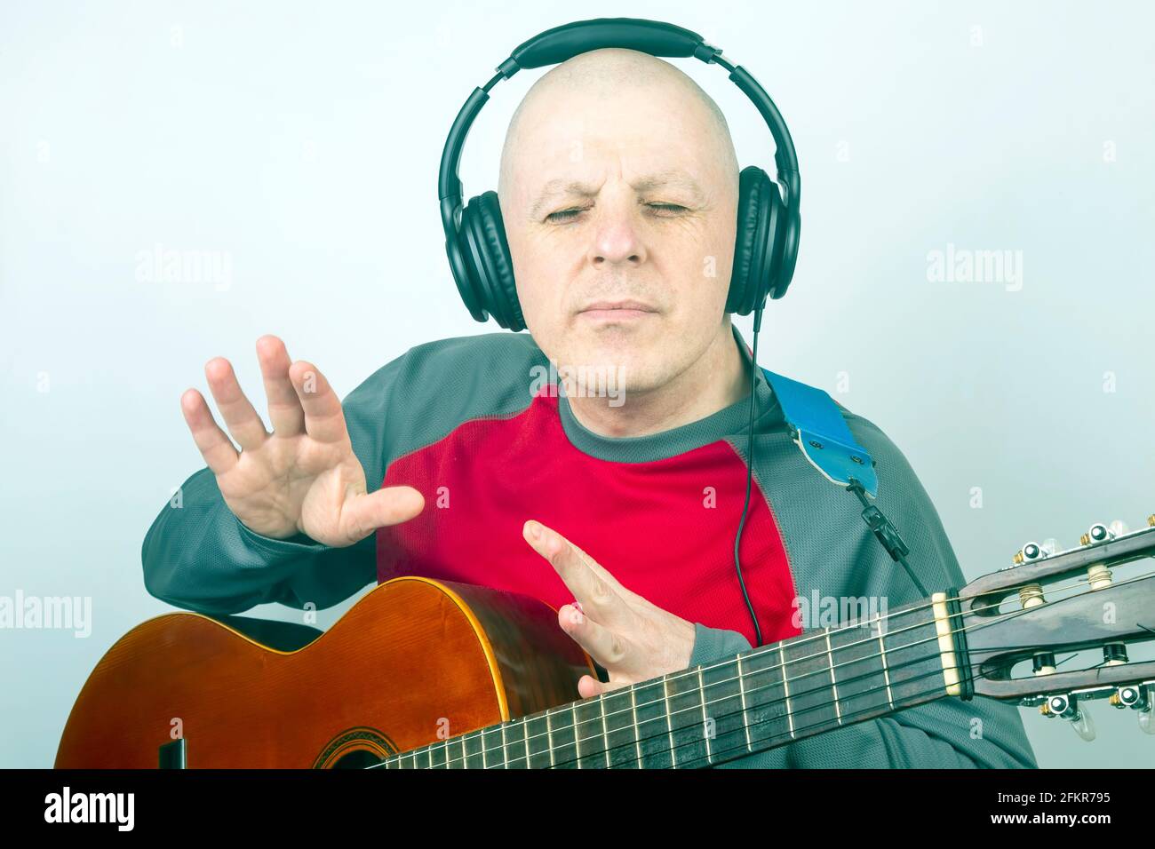 uomo con una chitarra classica e cuffie sulla testa ascolto di musica Foto  stock - Alamy