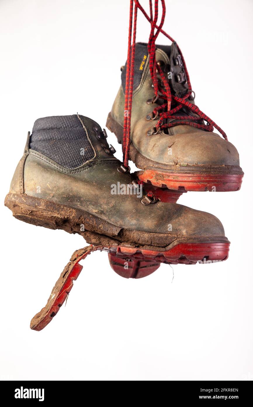 Coppia di usurati stivali vecchi, uno scarpone con la suola coming off Foto Stock