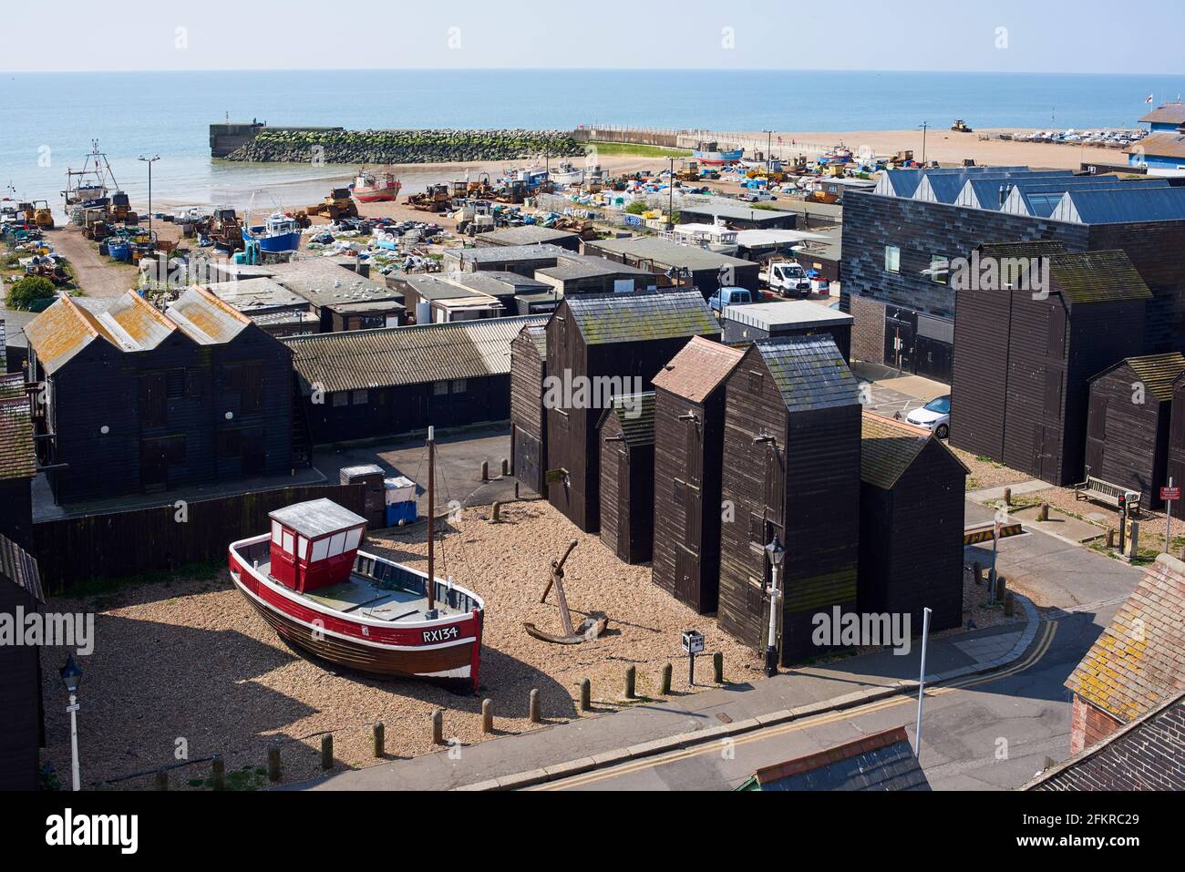Il quartiere dei pescatori e la spiaggia di Hastings, East Sussex, Regno Unito, con barche da pesca e negozi di reti Foto Stock