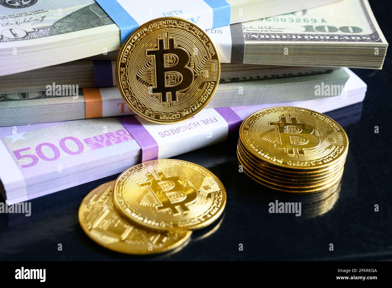 Bitcoin e pile di denaro, gran parte delle banconote in euro e dollari USA e monete d'oro bit. btc digitale virtuale criptovaluta bitcoin con pila di contanti. Concetto di Foto Stock