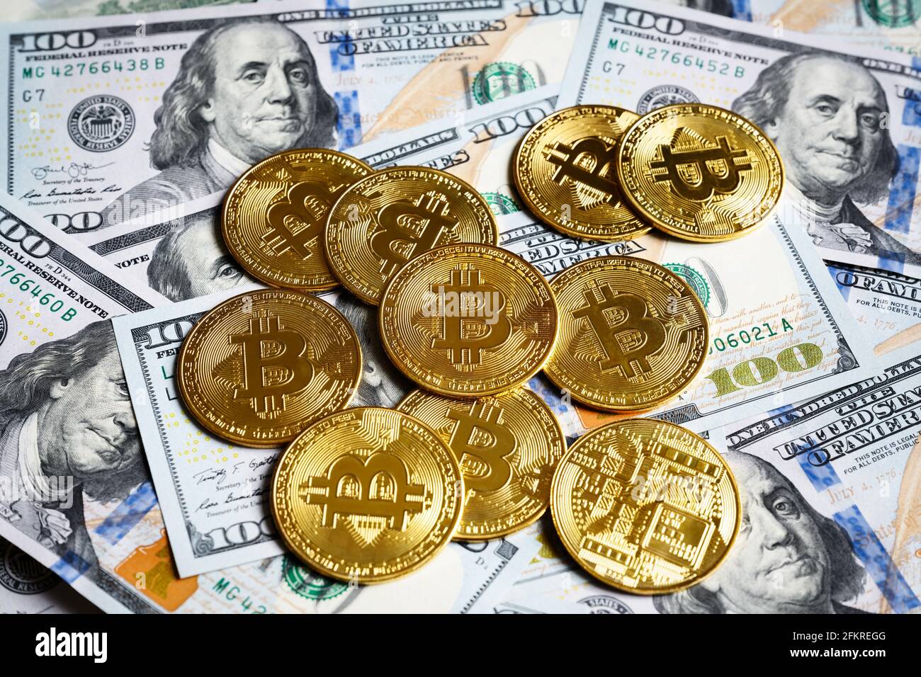 Bittcoin e dollari USA, moneta digitale criptovaluta bitcoin e banconote. Pila di monete d'oro bit sullo sfondo delle banconote del dollaro. Concetto di "Mone virtuale" Foto Stock