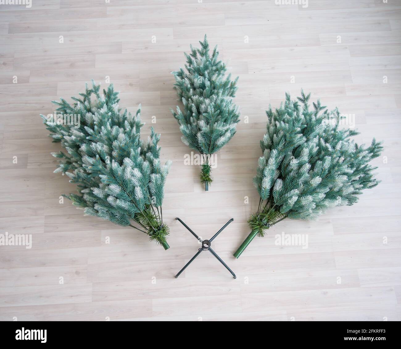 Primo piano di pezzi di albero di Natale artificiale. Il processo di raccolta e decorazione dell'albero per il nuovo anno. Vista dall'alto. Composto Foto Stock