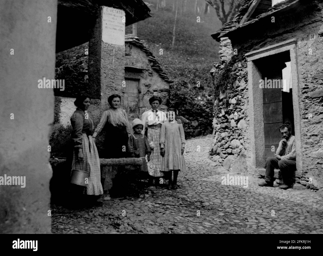 AJAXNETPHOTO. c.1908 -14. ROMA, ITALIA. - ALBUM DEL GRAND TOUR; SCANSIONI DA NEGATIVI ORIGINALI DEL VETRO IMPERIALE - DONNE E BAMBINI POSANO PER LA MACCHINA FOTOGRAFICA FUORI DI UN LAVATOIO PUBBLICO MENTRE UN UOMO SEDUTO GUARDA SOPRA. FOTOGRAFO: SCONOSCIUTO. FONTE: AJAX VINTAGE PICTURE LIBRARY COLLECTION.CREDIT: AJAX VINTAGE PICTURE LIBRARY. REF;1900 6 06 Foto Stock