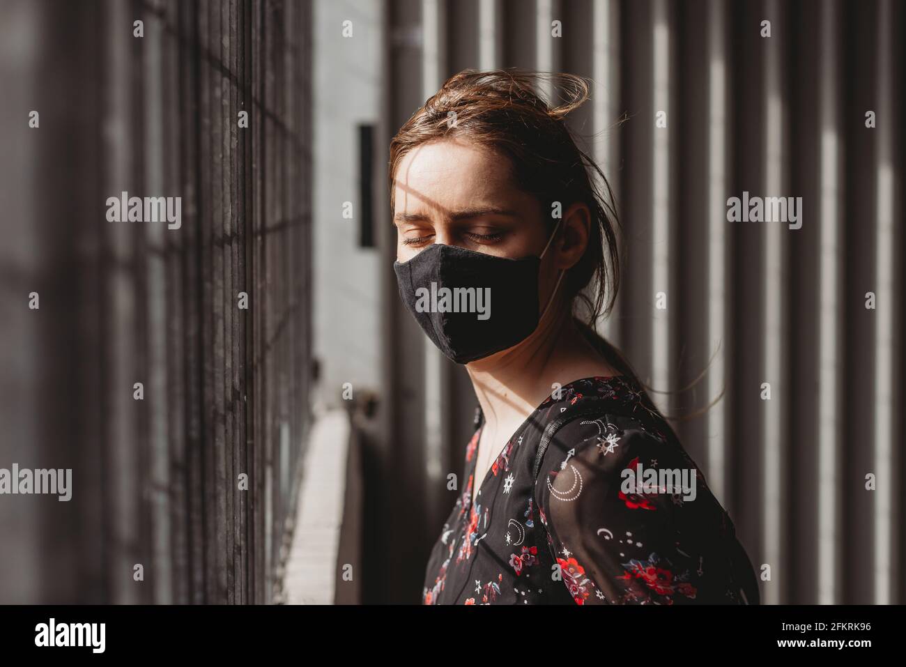 Donna triste depressa gridando e piangendo sotto maschera per la protezione dal virus corona covid-19 , concetto di salute mentale Foto Stock