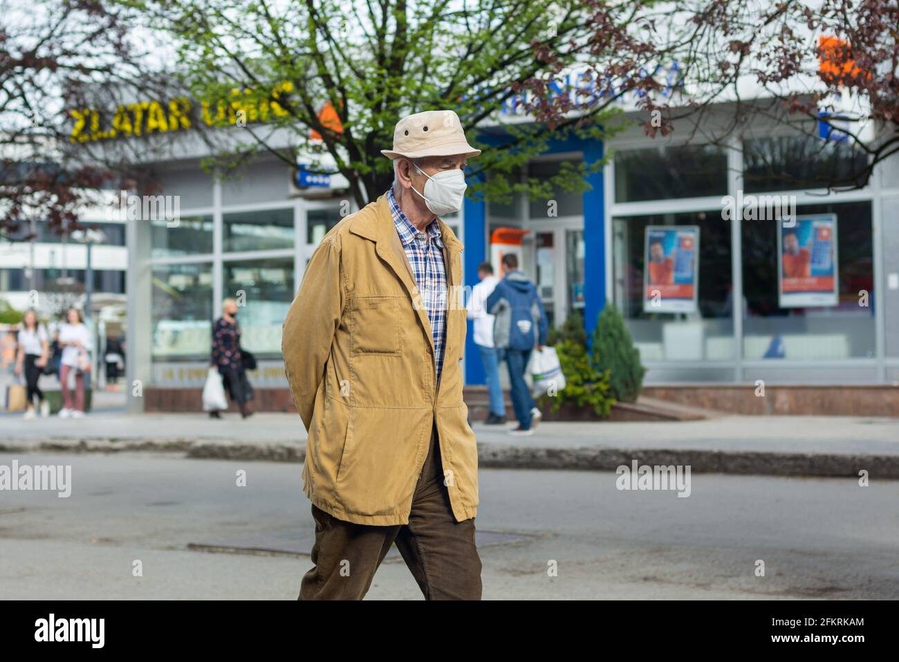 Sarajevo, Bosnia-Erzegovina - 28.04.2021: Uomo anziano che cammina con la maschera facciale sulla strada dopo la riapertura, dopo il covid 19 blocco Foto Stock
