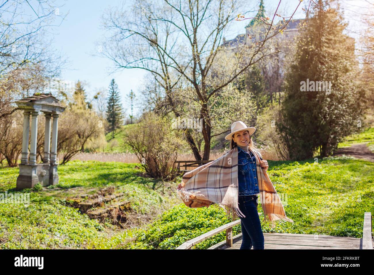Felice turista donna passeggiate dal Castello Olesko in primavera parco ammirando la vista dell'architettura. Visite turistiche in Ucraina occidentale. Foto Stock