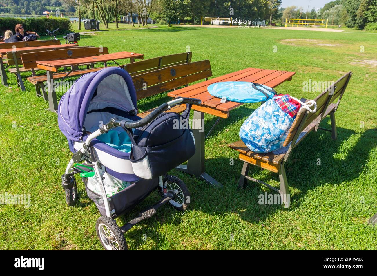 POZNAN, POLONIA - 02 settembre 2017: Passeggino accanto a un tavolo di legno e panchine su erba verde in un parco Foto Stock