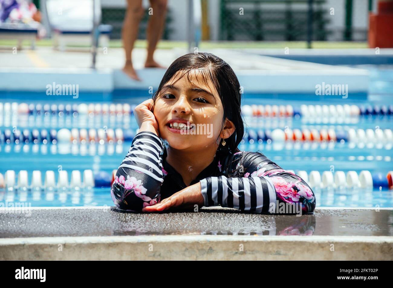 Ritratto di una ragazza sorridente in piscina. Foto Stock
