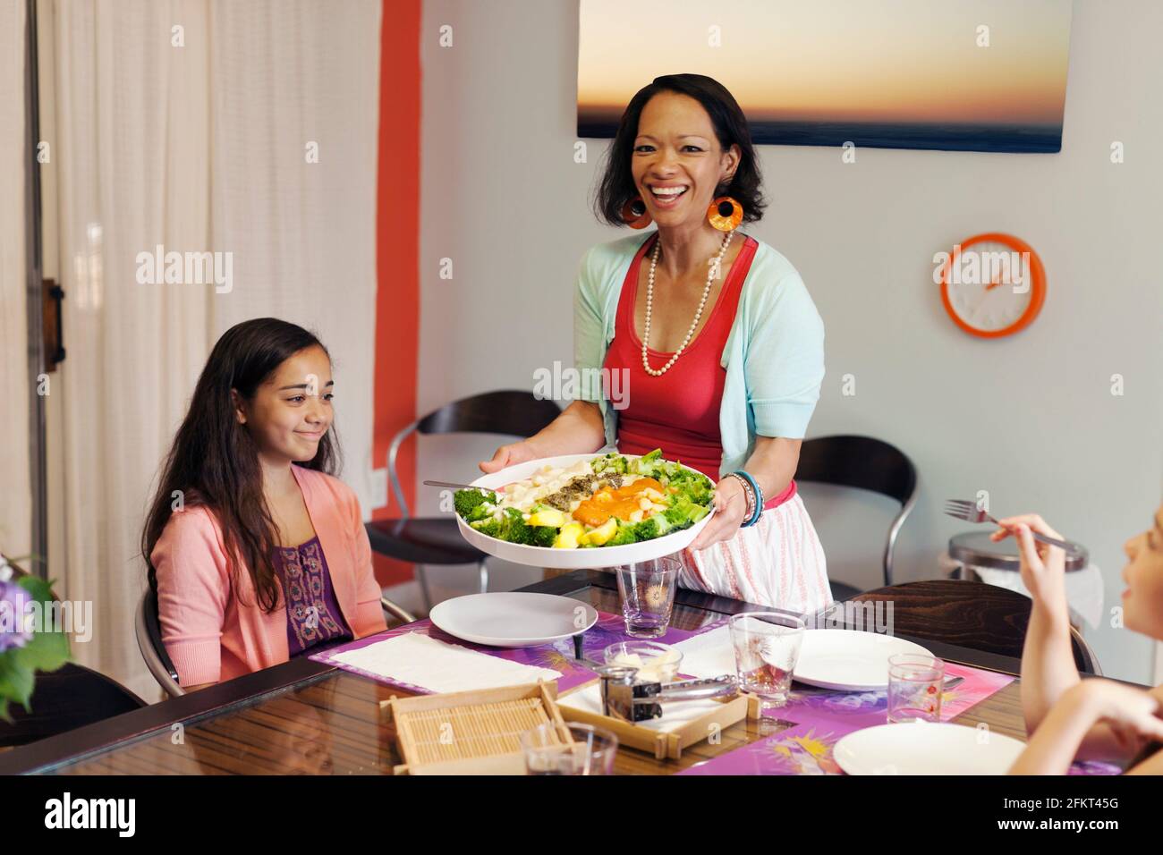 Donna che serve gli gnocchi e il piatto a base di broccoli Foto Stock