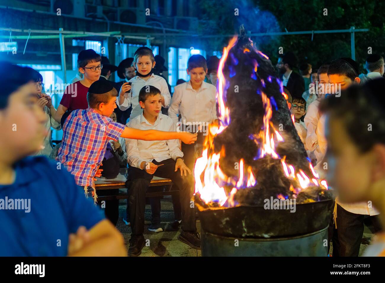 Haifa, Israele - 29 aprile 2021: Gli ebrei ultra-ortodossi celebrano la festa di Lag BaOmer, con i bambini che si riuniscono intorno ad un fuoco. Haifa, Israele Foto Stock