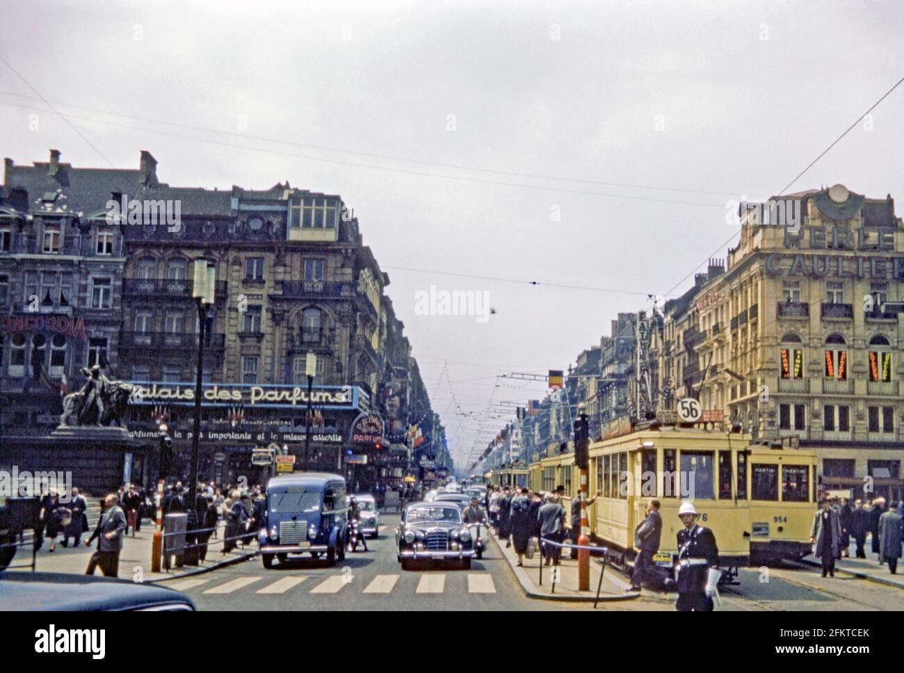 Guardando lungo un trafficato Boulevard Anspach a Place de Bourse, Bruxelles, Belgio c.1958. La strada principale nel centro della città ha sia tram e traffico a motore e i pedoni sono in corsa. I gradini a sinistra conducono alla Borsa di Bruxelle. I tram corrono lungo la strada 56. Il percorso non esiste più e l'intera area è ora pedonale e priva di traffico. Questa immagine proviene da un vecchio lucido a colori Kodak dilettante da 35 mm, una fotografia degli anni '50. Foto Stock