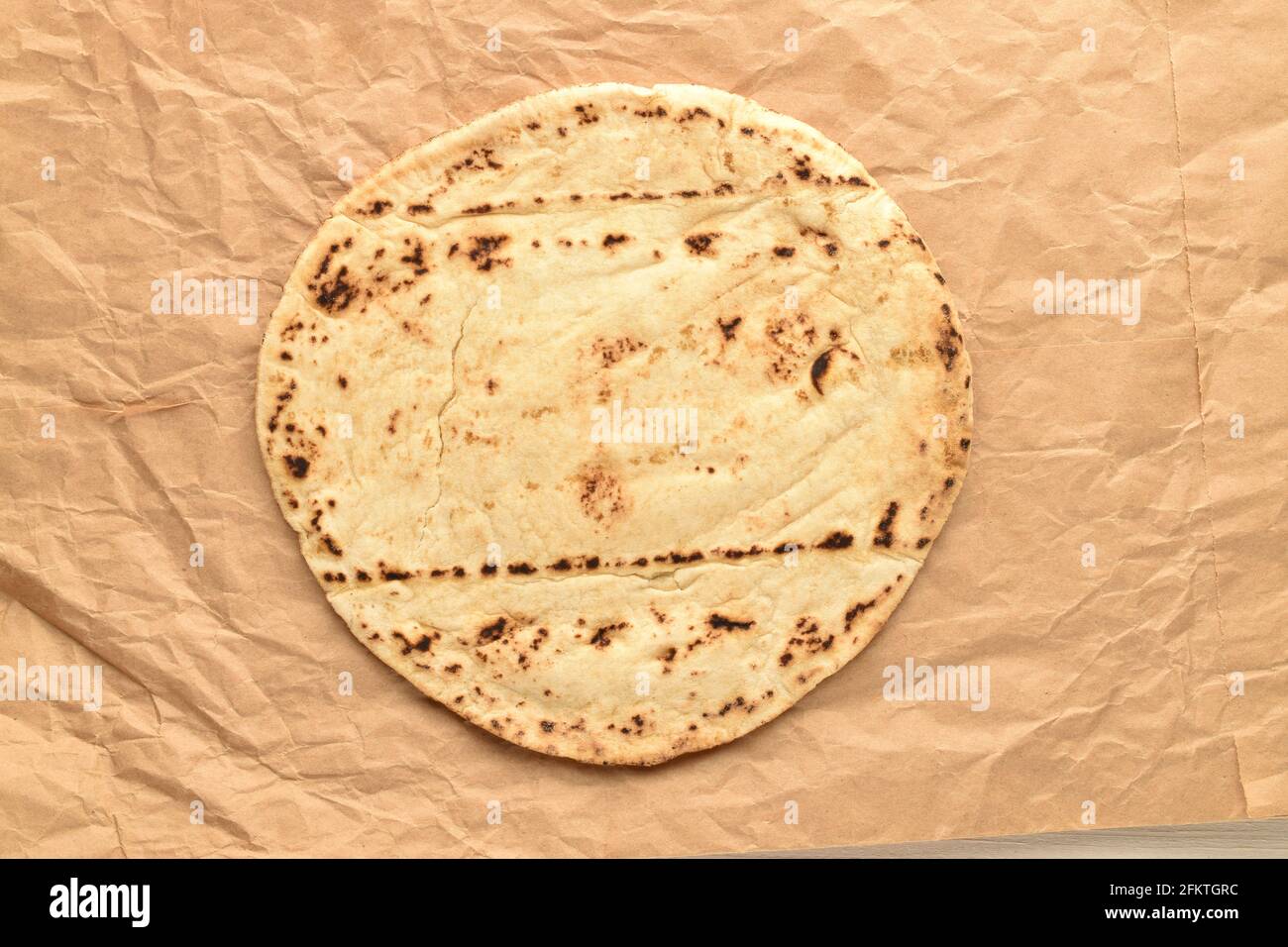 Un pane pita appena sfornato su carta marrone, primo piano, vista dall'alto. Foto Stock