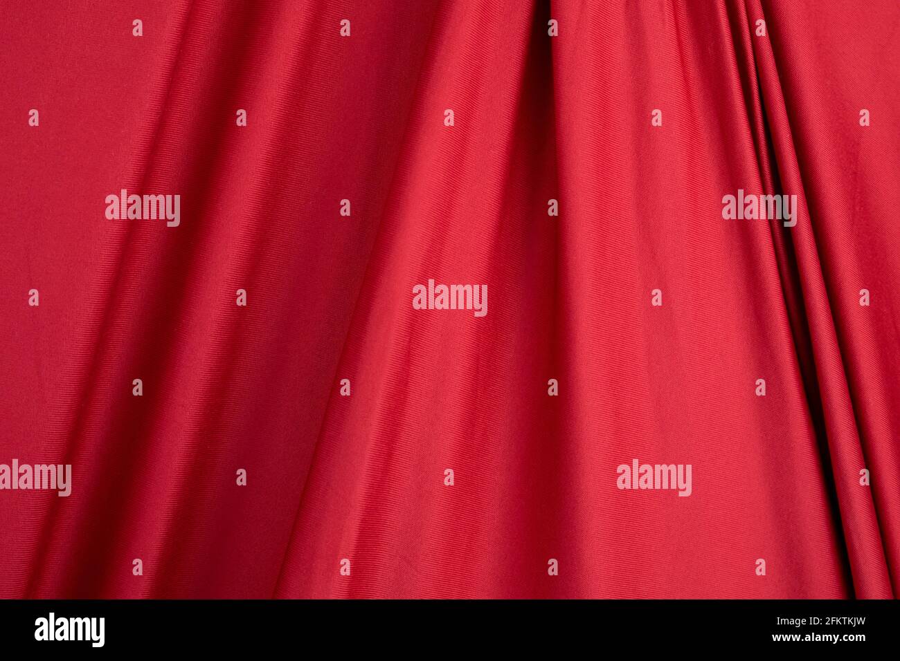 Texture, sfondo, modello. Tessuto di seta. Drappeggi e tappezzeria in seta rossa. Tessuti solidi per lo sfondo, tende, bandiere e tende. Foto Stock