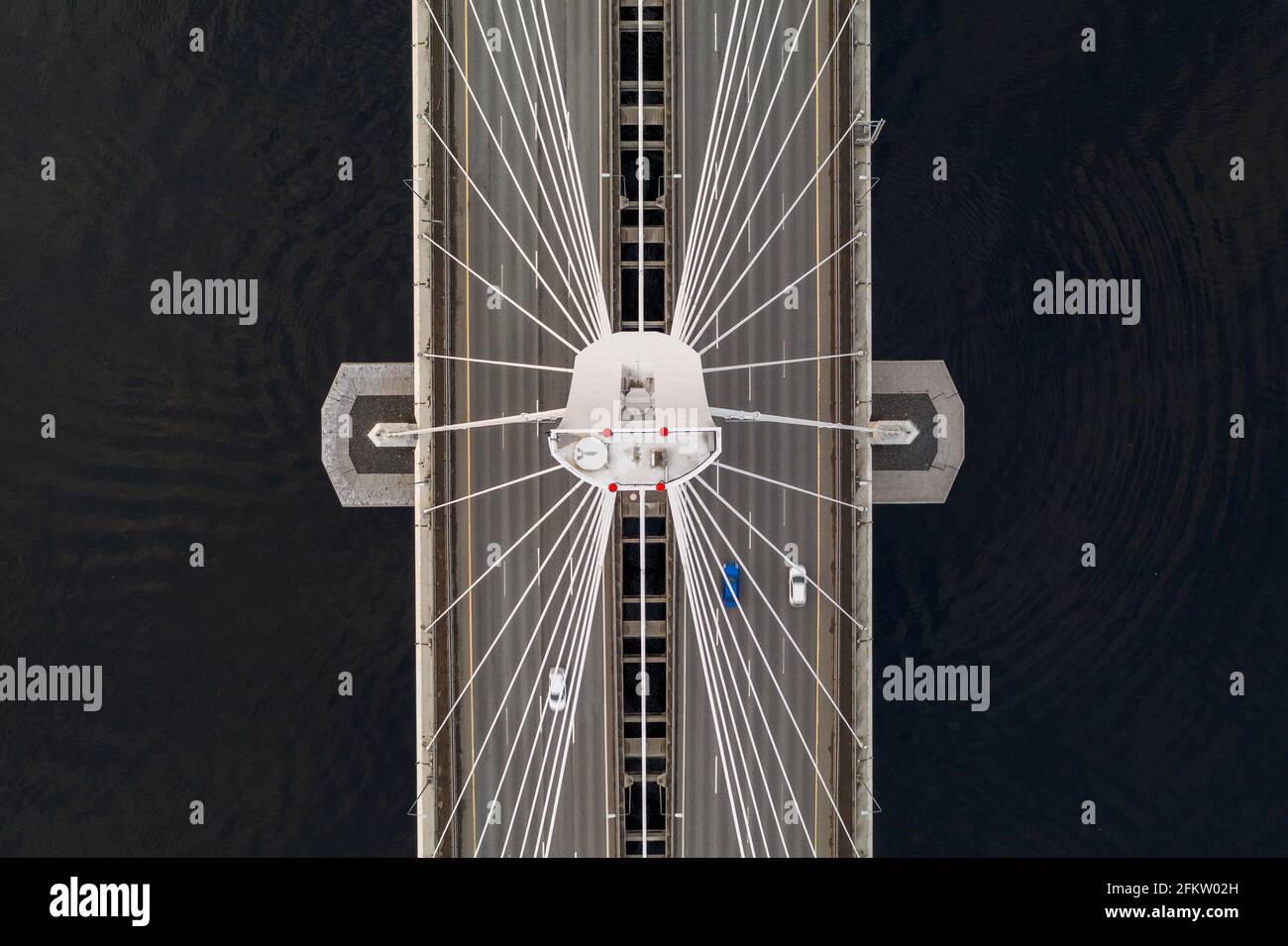 Foto aerea di un ponte fermacavo con auto che guidano e. acque nere su entrambi i lati Foto Stock