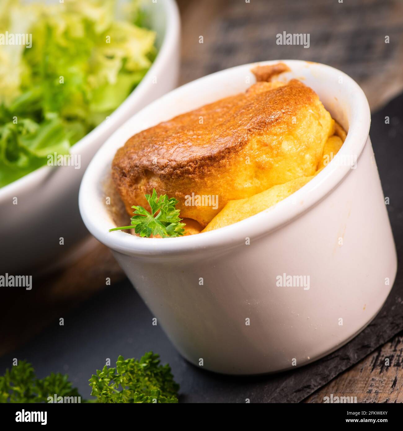 Soufflé di uova di formaggio su un panno rustico su sfondo di legno Foto Stock