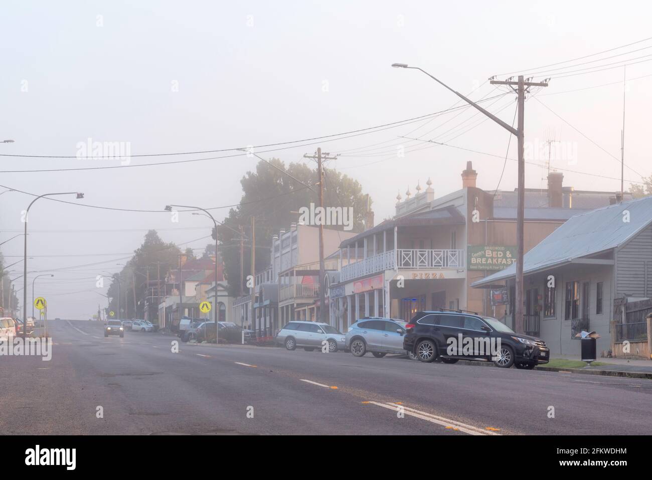 Guardando verso ovest lungo la strada principale di nella strada principale di Braidwood nella Tablelands meridionale del nuovo Galles del Sud, Australia in una mattinata nebbiosa Foto Stock