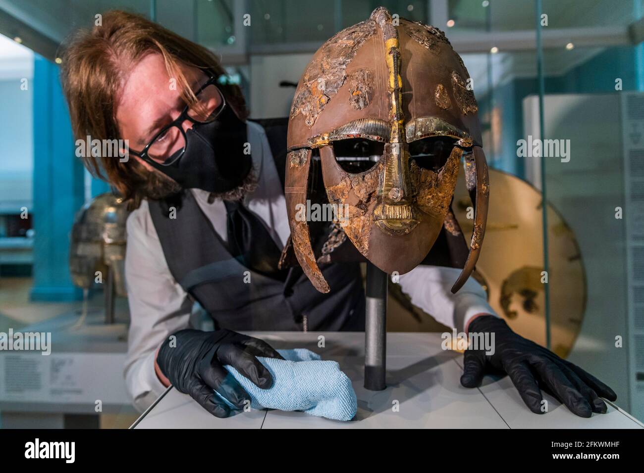 Londra, Regno Unito. 4 maggio 2021. Jim Peters, responsabile della collezione: Care and Access, con l'iconico casco in ferro ornato - i tesori di Sutton Hoo al British Museum. Hanno presentato nel film di successo The Dig Starring Ralph Fiennes e Carey Mulligan, non sono stati visti dal pubblico dal Museo chiuso per la prima volta nel marzo 2020 a causa della pandemia di Coronavirus. Credit: Guy Bell/Alamy Live News Foto Stock