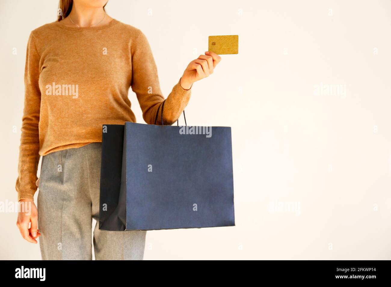 Giovane donna slim in classico outfit alla moda, pullover marrone e pantaloni  grigio sciolto sono andati