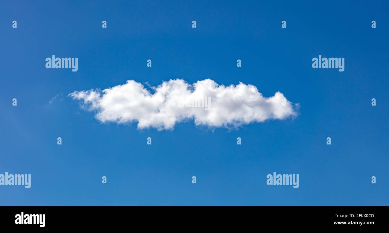 Nuvola bianca su cielo blu. Una sola nuvola soffusca isolata su un cielo limpido, soleggiato giorno primaverile. Foto Stock